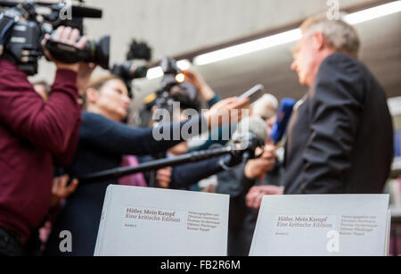 Monaco di Baviera, Germania. 8 Gen, 2016. Project manager dell'Academic Edition della versione annotata del 'Hitler Mein Kampf - una edizione critica uguale', Christian Hartmann (R), sorge accanto ai due volumi dell'edizione (anteriore, in basso), mentre parla con i giornalisti nel corso di una conferenza stampa presso l'Institut fuer Zeitgeschichte" (Istituto per la storia contemporanea) . Credito: dpa picture alliance/Alamy Live News Foto Stock