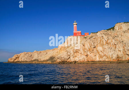 Faro di Punta Carena sulle rocce costiere al Mar Mediterraneo in Isola di Capri, visto da una barca a motore tour. Foto Stock