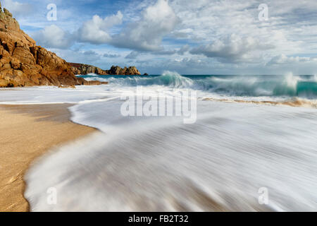 Un'onda presso la splendida spiaggia di Porthcurno Foto Stock