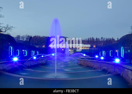 La grande cascata nel giardino a Alnwick in Northumberland illuminazione notturna in inverno con fontana visualizza Foto Stock