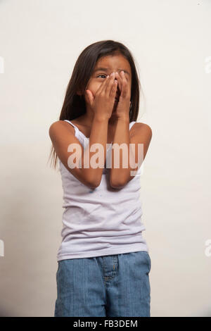 Un dimostrativo Native American Girl membro della tribù Acjachemen copre il suo volto a sorpresa. Modello di rilascio Foto Stock