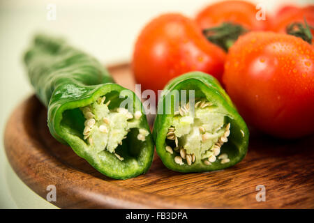 Pomodori e peperoni su una superficie in legno Foto Stock