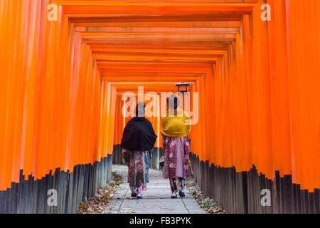 Le donne in kimono tradizionali camminando lungo il Senbon Torii (migliaia di Torii gates) in Fushimi Inari Shrine, Kyoto, Giappone Foto Stock