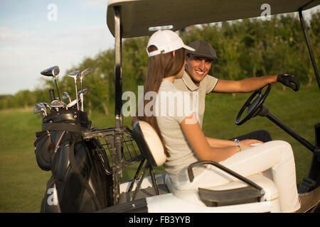 Coppia giovane a carrello da golf Foto Stock