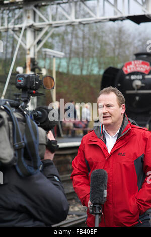 Sky tv reporter tenendo il microfono e consegnando pezzo alla telecamera di fronte al vago Scotsman, East lancashire Railway, Bury lancashire uk Foto Stock