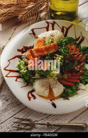 Insalata di verdure fresche con uovo in camicia e crostini. Foto Stock