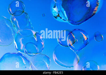 Bolle di sapone su uno sfondo blu, astratto Foto Stock