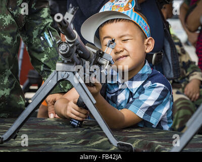 Bangkok, Tailandia. Il 9 gennaio, 2016. Un ragazzo Thai gioca con un esercito di mitragliatrice durante la giornata per i bambini le feste presso il Royal Thai dell esercito Palace Guard, seconda divisione Base di cavalleria in Bangkok. National Bambini Giorno cade il secondo sabato di quest'anno. Governo thailandese agenzie sponsor child friendly eventi e i militari di solito si apre le basi dell'esercito per i bambini che vengono a giocare su carri armati e pezzi di artiglieria. Credit: Jack Kurtz/ZUMA filo/Alamy Live News Foto Stock