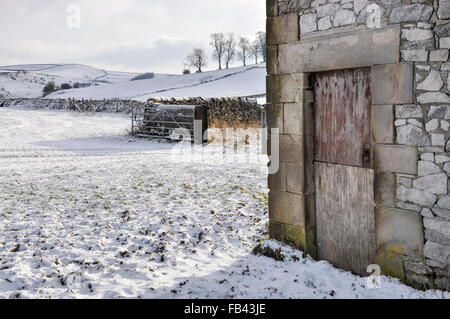 Una vecchia porta di legno su un fienile in pietra nel quartiere di picco in inverno. Foto Stock