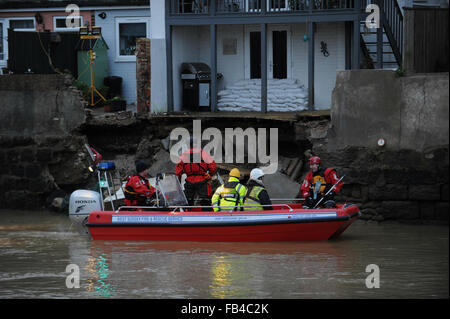 I membri dell'Agenzia per l'ambiente e il West Sussex fuoco e il servizio di soccorso ispezionare il danno a un alluvione del fiume parete che è crollato lungo il fiume Arun nella storica cittadina di ARUNDEL nel West Sussex, in Inghilterra. Foto Stock