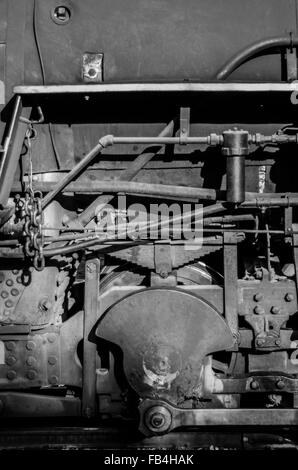 Immagine in bianco e nero degli ingranaggi e delle tubazioni su un vecchio motore a vapore Foto Stock