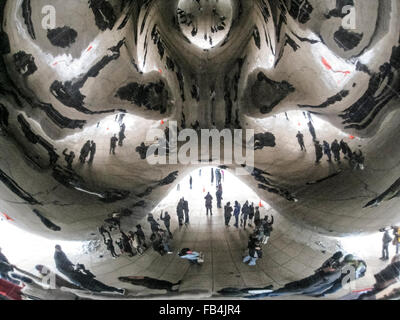 Riflessi distorti sono visti di turisti in cerca di sotto a "fagiolo", il popolare il soprannome di 'Cloud Gate,' un 110-ton scultura ellittico in Millennium Park di Chicago, Illinois, Stati Uniti d'America. Artista britannico Anish Kapoor ha creato il monumento lucido con pezzi di acciaio inossidabile che sono stati saldati tra loro e quindi altamente lucidata per eliminare visivamente tutte le cuciture. Le opere d'arte ha avuto due anni per completare e fu inaugurato nel 2006. Da allora è diventata una delle principali attrazioni turistiche nella città ventosa. Foto Stock