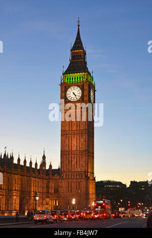 La Torre Big Ben Elizabeth ha illuminato il quadrante dell'orologio e la struttura del proiettore al crepuscolo con veicoli ai semafori sul Westminster Bridge Londra Inghilterra Regno Unito Foto Stock