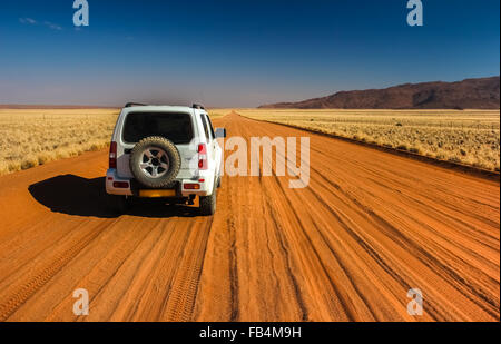 Auto solitario sul rettilineo di sabbia pad, Namibia Foto Stock