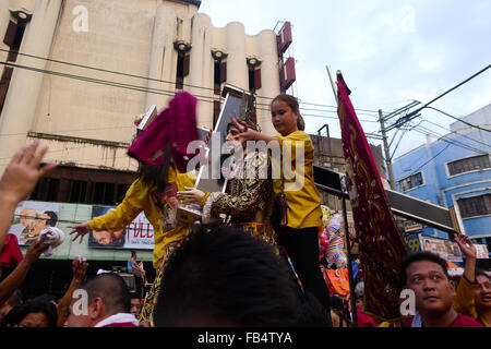 Manila, Filippine. 9 Gen, 2016. Una donna gettando indietro il telo viso su uno dei devoti. Ogni anno migliaia di pellegrini da tutto il paese venuti a Manila per essere parte della processione del Nazareno nero. Tutti i partecipanti al corteo di speranza che essi avranno la possibilità di toccare la statua in legno. Essi sperano che questo li proteggerà da eventuali danni e per garantire la salute. © Josefiel Rivera/Pacific Press/Alamy Live News Foto Stock