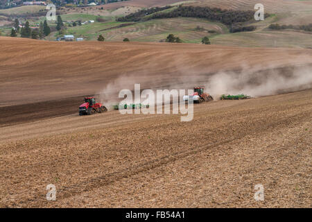 Caso il trattore cingolato coltivando un campo con un coltivatore nella regione Palouse di Washington Foto Stock