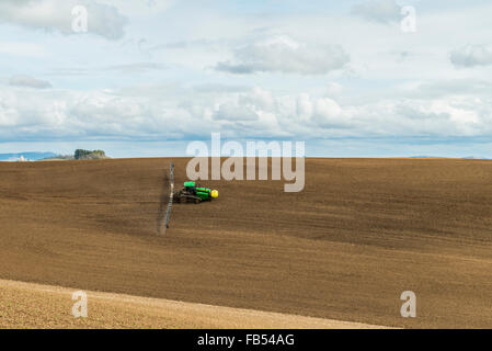 John Deere via trattore configurato con bracci di irrorazione di fertilizzanti di spruzzatura su un garbonzo bean seedbed nella regione Palouse di Foto Stock