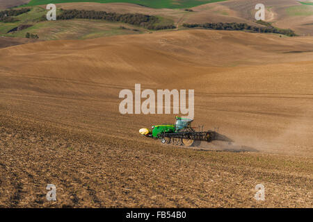 John Deere via trattore configurato con bracci di irrorazione di fertilizzanti di spruzzatura su un garbonzo bean seedbed nella regione Palouse di Foto Stock