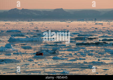 Barca tra gli iceberg nella baia di Disko, Ilulissat Foto Stock