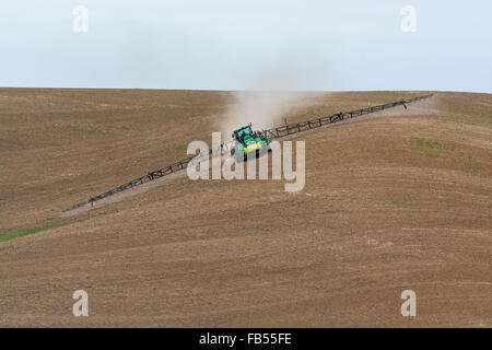 John Deere via trattore configurato con bracci di irrorazione di fertilizzanti di spruzzatura su un garbonzo bean seedbed nella regione Palouse di Foto Stock