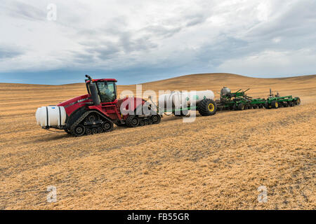 Caso trattore Quadtrac tirando un serbatoio dell'ammoniaca anidra e applicatore applicando la anidro per un campo in anticipo di preparazione Foto Stock