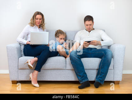 Famiglia moderna valori. Padre, madre e figlia utilizzando dispositivi elettronici. Foto Stock