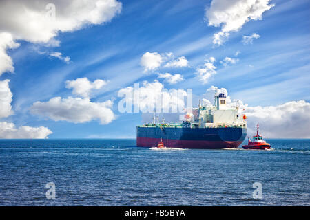 Nave cisterna con la scorta rimorchiatori lasciando port. Foto Stock