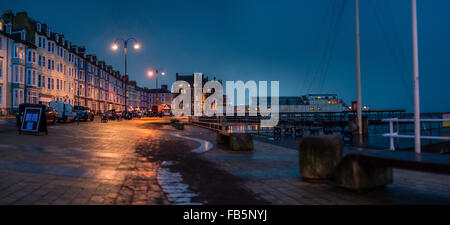 Aberystwyth Wales UK, domenica 10 gennaio 2016 una immagine panoramica delle luci di strada riflette il lungomare umido su un grigio molto nuvoloso pioggia domenica sera a Aberystwyth sulla West Wales coast UK Photo credit: Keith Morris / Alamy Live News Foto Stock