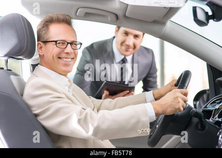 Assistente di vendita mostra auto per il cliente Foto Stock