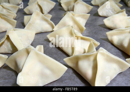 Fatti a mano gnocchi Cinesi sul vassoio prima della cottura. Foto Stock