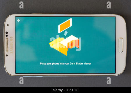 Uno smartphone che mostra una schermata di Google app di cartone - 'Inserire il telefono nel tuo Buio Shader viewer' Foto Stock