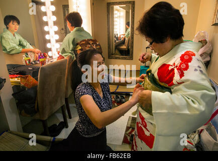 Delray Beach, Florida, Stati Uniti d'America. Decimo gen, 2016. Amici di Koto membri Hisako Kolinsky, (R), si ottiene una mano con il suo kimono da Emiko Koto, (C), mentre Etsuko Nakamura, (L), anche ottiene pronto per le loro prestazioni durante i trenta otto Oshogatsu annuale Festival di domenica 10 gennaio 2016 presso il Museo Morikami e giardini giapponesi in Delray Beach. © Bill Ingram/Palm Beach post/ZUMA filo/Alamy Live News Foto Stock