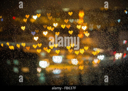 Piccolo cuore colorati bokeh di fondo dietro il vetro bagnato per il giorno di san valentino amore sfondo concept Foto Stock