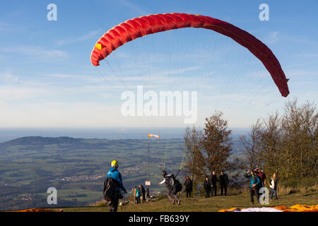 Un parapendio, guardato da curiosi, lancia fuori dal monte Gaisberg in Austria Foto Stock