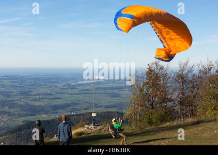 Un parapendio il tentativo di gonfiare la sua ala come egli tenta un lancio di retromarcia con forte vento contrario sul monte Gaisberg, Salisburgo Foto Stock