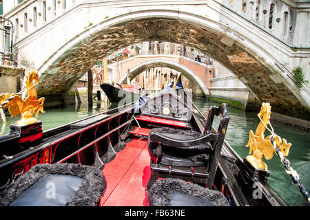 Vista dalla gondola viaggio durante il viaggio attraverso gli stretti canali con numerosi ponti di Venezia Italia Foto Stock