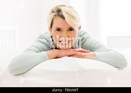 Tranquilla metà di età donna sdraiata sul letto di casa Foto Stock