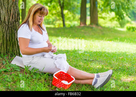 Il 50-anno-vecchia donna maglia in estate park Foto Stock