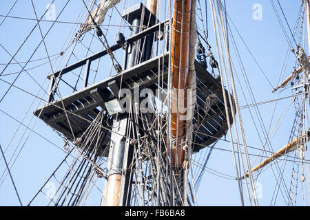 Grand Turk, XVIII secolo replica man-di-guerra in nave a vela. Vista dal ponte del Crow's Nest, piattaforma di avvistamento, montante e manovre contro il cielo blu. Foto Stock