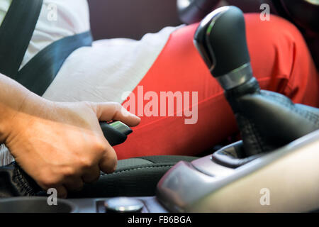 Donna di mano preleva il freno di stazionamento in un auto Foto Stock