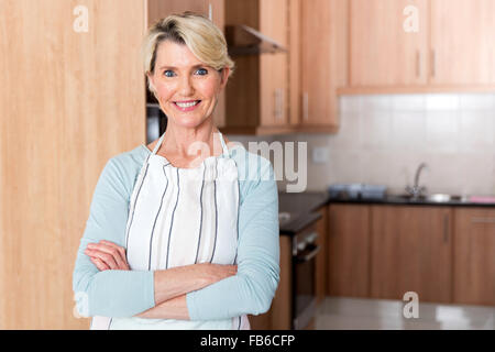 Ritratto di donna senior in piedi in cucina Foto Stock