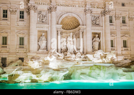 Vista notturna di acqua, statue e rocce artificiali in architettura di fontana romana Foto Stock