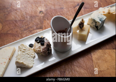 Una selezione di formaggi con un piatto di assaporare presentata su un piatto bianco in un ristorante italiano. Foto Stock