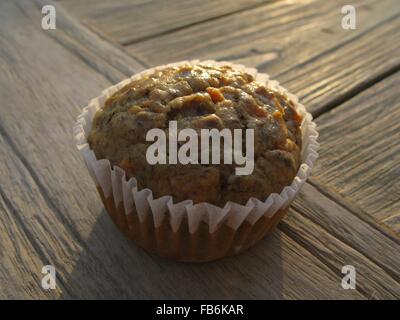 Banana--carota muffin in legno di noce con flaxseeds nella luce del mattino Foto Stock