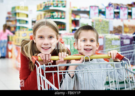 I bambini con carrello di shopping in un supermercato Foto Stock