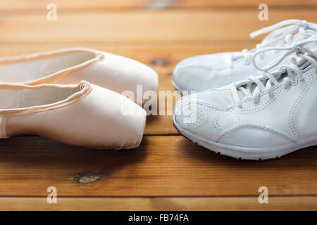 Close up sneakers e pointe shoes su legno Foto Stock