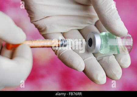 La siringa con il flacone in mano di un medico Foto Stock