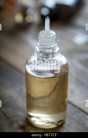 Sigaretta elettronica aroma liquido su sfondo di legno, close up Foto Stock