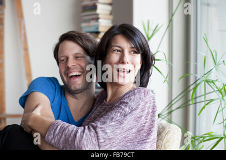 Coppia matura che abbraccia ogni altra e sorridente Foto Stock