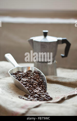 Scoop pieno di caffè in grani con caffè sul sacco Foto Stock